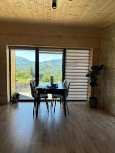 a dining room with a table and chairs and a large window at Evergreen cottage in Slavske
