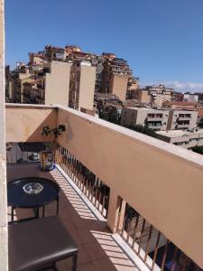 a balcony with a table and a view of a city at Eclisse quinto piano senza ascensore in Palermo