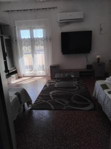 a living room with a flat screen tv on the wall at Eclisse quinto piano senza ascensore in Palermo