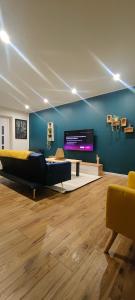 a living room with a couch and a tv at OasisNoir in Calonne-Ricouart +24 photos
