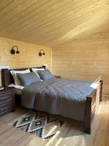 a bedroom with a bed and a wooden ceiling at Evergreen cottage in Slavske