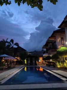 a night view of a swimming pool at a resort at Melati Hotel central kuta mandalika in Kuta Lombok