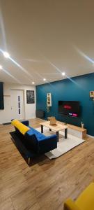 a living room with a couch and a table at OasisNoir in Calonne-Ricouart