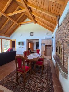 a kitchen and living room with a table and chairs at Vikendica Twins in Donji Vakuf