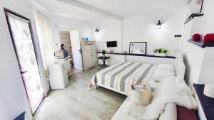 a white bedroom with a bed and a window at Casa Fotografului Studio Marines in Constanţa