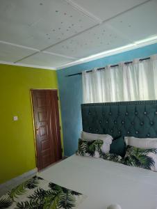 a bedroom with a large bed with green walls at ADONAI Homes in Malindi