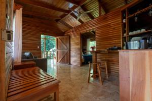 a room with wooden walls and a kitchen with a bar at Esquipulas Rainforest in Quepos