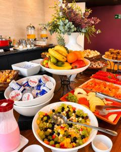 a buffet with bowls of fruit and vegetables on a table at Intercity Faria Lima Address in São Paulo