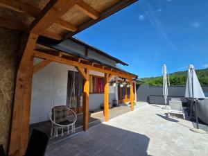 a patio with a umbrella and a chair and an umbrella at Vikendica Twins in Donji Vakuf +10 photos