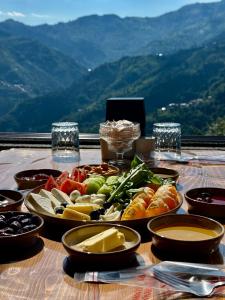 a table topped with plates of food on top of a mountain at Alfa Dağevleri in Rize +36 photos