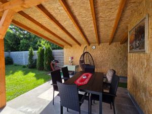 a dining table and chairs under a wooden pergola at Vikendica Twins in Donji Vakuf