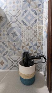 a container filled withuming utensils in front of a tile wall at Masseria Mustazzo in Siponto