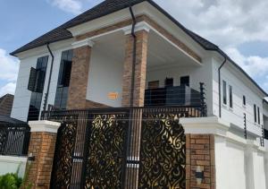 a house with a wrought iron fence at Mega Luxury Apartment in Asagba