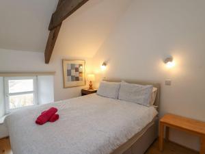 a bedroom with a bed with two red pillows on it at Tegfan in Newport