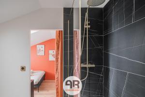 a shower in a bathroom with black tiles at La Casa Marrakech - Superbe studio rénové - 2 pers in Fontaine