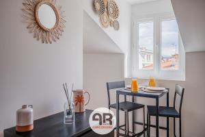 a dining room with a table and chairs and a mirror at La Casa Marrakech - Superbe studio rénové - 2 pers in Fontaine +9 photos