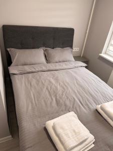 a large bed with white sheets and pillows on it at Apartment Ventos 55 in Mažeikiai