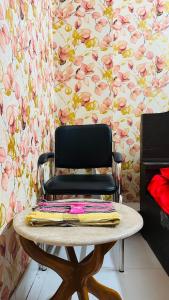 a black chair with a table in a room with flowers at Hotel Paradise Residential in Dhaka