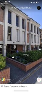 a large white building with bushes in front of it at Séjour Insolite ,SPA SAUNA parking gratuit in Troyes