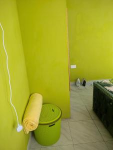 a green room with a trash can and a yellow wall at ADONAI Homes in Malindi +11 photos