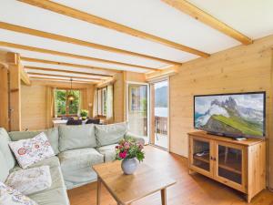 a living room with a couch and a tv at Guardian Gate Lodge in Iseltwald