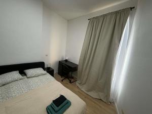 a bedroom with a bed and a desk and a window at 1 Chambre Moyenne avec television in Charleroi