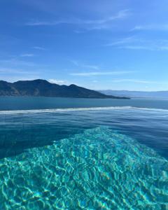 a large body of water with mountains in the background at Casa Gaia GuestHouse in Ilhabela