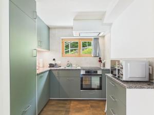 a kitchen with gray cabinets and a window at Guardian Gate Lodge in Iseltwald