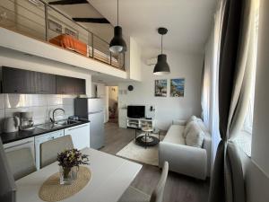 a kitchen and a living room with a couch and a table at Downtown Apartments Pula in Pula