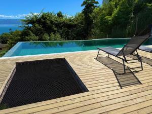 a chair sitting on a deck next to a swimming pool at Casa Gaia GuestHouse in Ilhabela