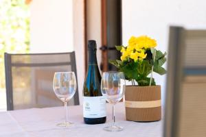 a bottle of wine and two wine glasses on a table at Residenze Camboni in Castiadas