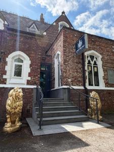 a brick building with a lion statue in front of it at Milverton Court by OYO in Manchester