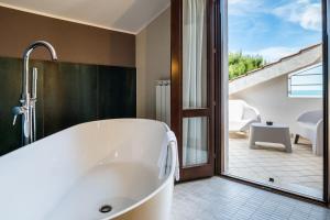 a bath tub in a bathroom with a sliding glass door at La Ginestra in Fiore Camere in Sirolo +65 photos