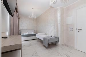 a bedroom with two beds and a desk at Hotel Aurora in Porto Cesareo