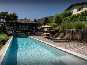 a swimming pool with chairs and a house at Chalet Kalyssia - OVO Network in Saint-Jorioz