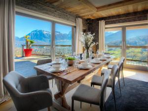 a dining room with a table and chairs and a large window at Chalet Kalyssia - OVO Network in Saint-Jorioz