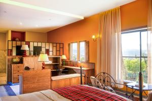 a bedroom with orange walls and a bed and a window at Kasbah Beldi in Lalla Takerkoust