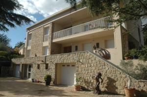 a building with a stone wall and a white garage at La Palma in Ajaccio