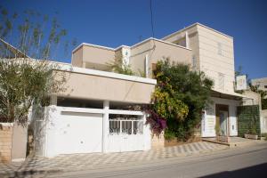 a white building with a white garage at Jasmin in Gabès