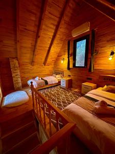 a room with three beds in a log cabin at Alfa Dağevleri in Rize