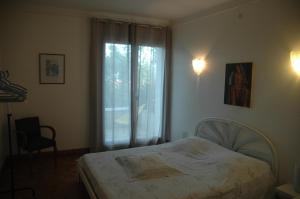 a bedroom with a bed and a large window at La Palma in Ajaccio