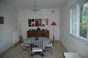 a dining room with a table and chairs and a chandelier at La Palma in Ajaccio