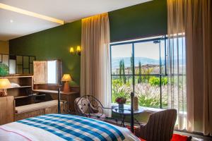 a bedroom with a bed and a large window at Kasbah Beldi in Lalla Takerkoust +116 photos