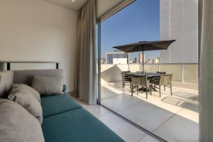 a living room with a couch and a table with an umbrella at Luggo Inter Residence - Região Central BH in Belo Horizonte
