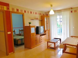 a living room with a tv on a dresser and a couch at COSTA DAURADA APARTAMENTS - Larimar in Salou