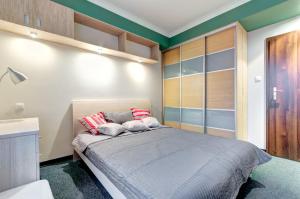 グダニスクにあるDom & House - Apartamenty Kamienice Nad Motławąのベッドルーム1室(大型ベッド1台、赤と白の枕付)