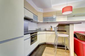 cocina con silla y sofá rojo en Dom & House - Apartamenty Kamienice Nad Motławą, en Gdansk