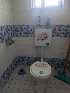 a bathroom with a toilet with a painting on it at ADONAI Homes in Malindi