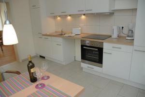 eine Küche mit einem Tisch mit einer Flasche und zwei Weingläsern in der Unterkunft Ferienwohnung Lühebogen in Jork