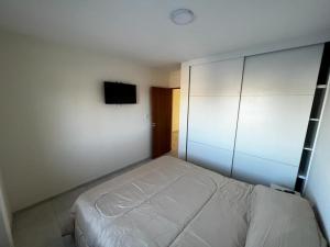 a bedroom with a white bed and a tv at uriburu45 in Malargüe +10 photos